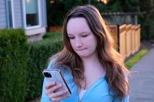 a teenage girl is dissatisfied with something she frowned her eyebrows new message groups social networks internet online being alone with herself adolescence psychological problems of children photo
