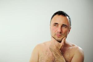 a brooding man with a bare torso Right side Here is a place for text Bare torso hairy chest Thoughts Beautiful sparkling blue eyes photo