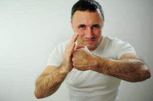 Hit from the left adult man is angry and hits his hand with his fist his hairy strong hands he has black hair and gray Dissatisfaction expressing negative emotions You will get what you deserve photo