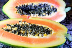 Dolly shot, a macro animation of a ripe papaya cut in half, saw the seeds and its texture that can be eaten. photo