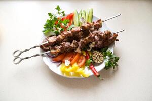 Homemade grilled kebabs of pork with vegetables, served on a slate plate closeup. horizontal photo