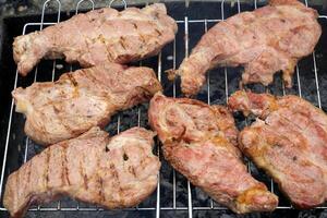 Grilled steaks rest on a barbecue grill fresh beef meat fillet steak on barbecue grill grid cooked over burned charcoal ready photo