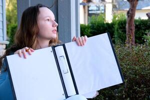 draw in an album with a simple pencil A girl sits draws in nature an eraser erases what she wrote looks into the distance and begins to erase the past again to start the future of a new clean slate photo