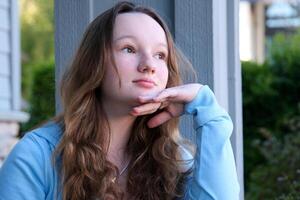 A pretty woman. She has long black hair and has beautiful lips. She sitting outside. Conceptual images of the lifestyle of a young girl. photo