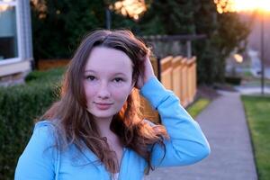 Woman smiling with perfect smile and white teeth in a park and looking at camera, Portrait of beautiful woman smiling and looking away at park during sunset. Happy cheerful girl laughing at park. photo