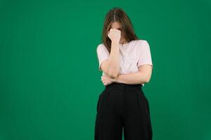 triste expresión cubierta cara con manos mientras llanto. depresión concepto. niña en chromakey hermosa facial caracteristicas real personas rosado camiseta blanco desollado europeo. negro acampanado amplio pierna pantalones foto