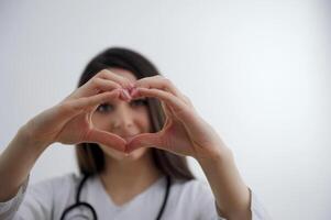 Close up of two female caucasian hands isolated on white background. Young woman forming shape of heart with her fingers. Horizontal color photography. Point of view shot photo