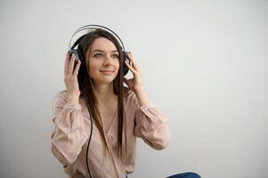 Relaxed young woman enjoying listening to music in wireless earphones, stress free meditation concept. Girl taking a break with audiobook. Horizontal banner with copy space photo