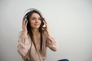 relajado joven mujer disfrutando escuchando a música en inalámbrico auriculares, estrés gratis meditación concepto. niña tomando un descanso con audio libro. horizontal bandera con Copiar espacio foto