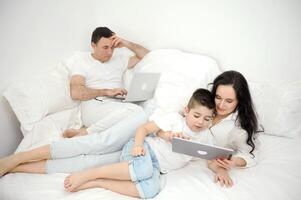 mom entertains son on tablet white clothes one bed rest apartments idyll spend time together be alone with yourself family modern communication online internet social networking computer communication photo