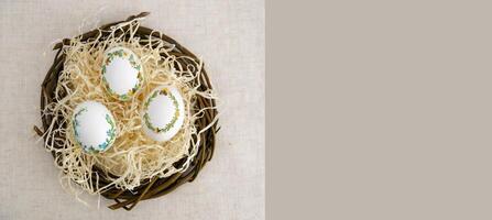 banner a lot of space for text coffee background Easter eggs decorated with painted embroidery ribbons on eggshell in nest three white eggs then on shavings advertising invitation postcard bigboard photo