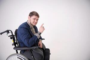 The man raised his finger up pointing to the empty disabled man is sitting in a wheelchair. He holds his hands on the wheel. Nearby are his colleagues photo