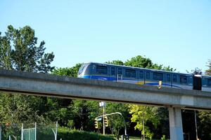 Sky trains from bottom up train of blue line passing against background of sky skytrain bridge in New Westminster Fraser River Tugboat, New Westminster Skyline. A tugboat travels up the Fraser River photo