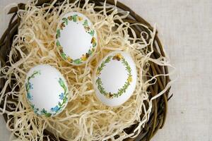 banner a lot of space for text coffee background Easter eggs decorated with painted embroidery ribbons on eggshell in nest three white eggs then on shavings advertising invitation postcard bigboard photo