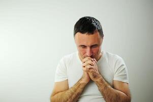 Adult man upset he put his hands on his face Prayer experience crying negative emotions suffering loneliness Studio on white background Close-up space for text Waiting for the end of the war photo