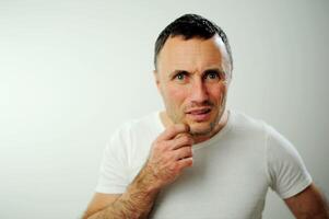 bewilderment angry unshaven man looks into the frame Point your finger directly at the camera Are you serious dissatisfaction disappointment Negative emotions white studio I will find you photo