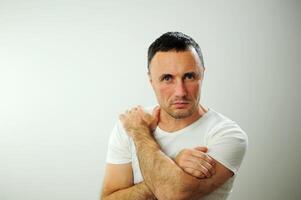 strength courage man with hairy arms unshaven white T-shirt on white background expression interest interest game advertising place for text severity pride invincibility invincibility crossed hands photo