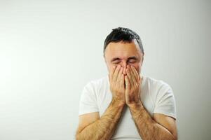 Adult man upset he put his hands on his face Prayer experience crying negative emotions suffering loneliness Studio on white background Close-up space for text Waiting for the end of the war photo