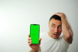 green screen chroma key phone man surprised face expression Surprised male hipster being stupefied as advertises something, Omg concept shouting WOW, with copy space fot your text. Shock content photo
