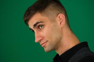 Portrait of a handsome young man emotions of a handsome man guy on a green background chromakey close-up dark hair young man photo