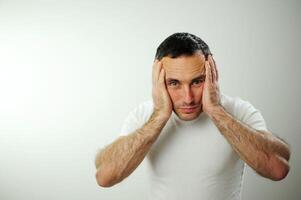 Appalled man emotional guy feeling sinking heart shortness of breath about emotional stress sensations isolated on grey white studio background, frightened person, horror, panic attack concept photo