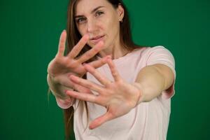 Beautiful young woman wearing casual white t-shirt over isolated background Rejection expression crossing arms and palms doing negative sign, angry face photo