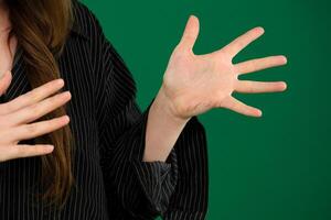 Young girl emotionally shouts expression of emotions with hands unrecognizable people hands palms fingers close-up on a green background chromakey feelings photo