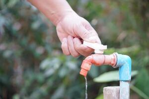 cerca arriba mano es torneado apagado grifo. concepto, salvar agua para ambiente. giro apagado grifo o grifo antes de partida. no lo hagas residuos agua por dejar eso goteo o goteando foto