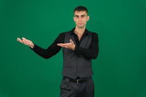 business man pointing at something as if he was presenting emotions of a handsome man guy on a green background chromakey close-up dark hair young man photo