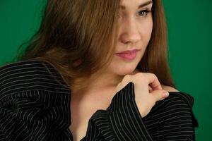 Concept close-up portrait of pretty girl, a young woman with long beautiful brown hair and a black jacket on a white background. In the studio in different poses showing emotions. photo