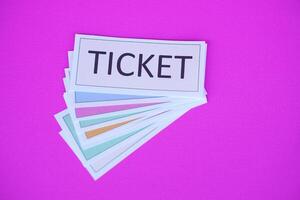 Pile of overlapped ticket paper cards on pink background. Concept, tickets for passing or enter to join activity or public vehicles. Tickets for playing games. Teaching aids. photo