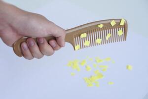 Hand holds comb and small pieces of paper. Equipment, prepared to do experiment about static electricity. Concept, Science lesson, fun and easy experiment. Education. Teaching aids. photo