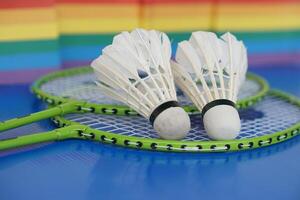 Badminton shuttlecocks on racket. Blurred rainbow colors background. Concept, sport, exercise, recreation activity for good health. Popular sport for all genders and LGBTQ worldwide. photo