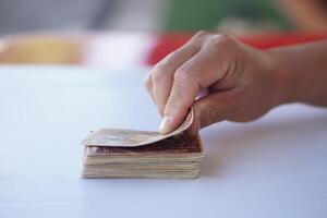 Close up hand holds paper card up from deck. Concept, play card. Recreational activity. Free time and hobby. Fortune reading from cards. Prediction for future life ,events. Astrology. Foretelling. photo