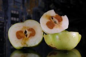 rotten spoiled fruits beautiful on top rotten inside grapes and apples throw in the trash old bad inedible spoiled close-up woman hands cutting examine and throwing food into a bucket photo