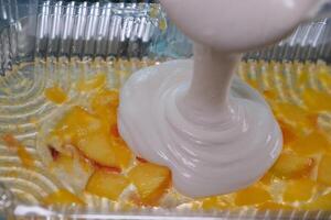 pour several layers of fruit jelly into a plastic container peaches blueberries curd dessert using gelatin for healthy joints in home cooking food photo