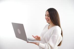 Young adult business woman typing on laptop computer working in internet, beautiful female professional user lady using pc technology doing online job in office or browsing web sit at home table photo