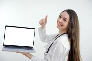 Happy doctor holding empty blank in hands. Female doctor showing a clipboard with blank paper. Close-up of a female doctor with lab coat and holding blank clipboard photo