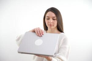 Smiling woman freelancer working distance via laptop computer while sitting in coffee shop. Happy caucasian female writing on net-book during rest in cafe. Hipster girl using notebook for chat photo