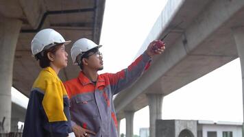 Asian engineering team Inspecting construction work radio command concrete road bridge highway video