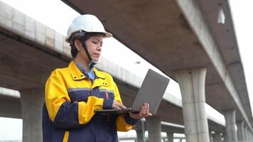 asiatico femmina ingegnere usi il computer portatile per ispezionare autostrada costruzione opera video