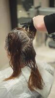 avvicinamento di un' parrucchiere mani tintura un' donna di capelli. stile di vita bellezza procedure nel il salone. alto qualità 4k metraggio video