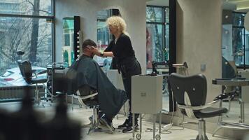 precisie kapsel. kapper gebruik makend van schaar Aan man's haar- in salon, benadrukkend schoonheid en Gezondheid. hoog kwaliteit 4k beeldmateriaal video