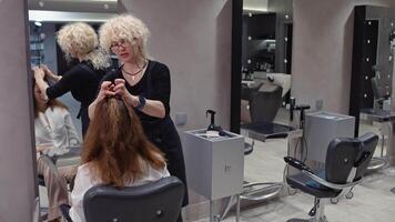 Haar Verjüngungskur Planung. Frau beschreibt gewünscht aussehen zu Barbier, diskutieren Farbe und Styling Techniken. hoch Qualität 4k Aufnahmen video