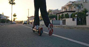 urbano esplorazione. adolescenziale ragazza equitazione elettrico scooter a tramonto, Abbracciare una persona attivo stile di vita. alto qualità 4k metraggio video