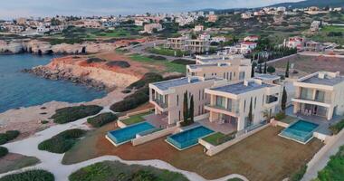 costero elegancia. aéreo puntos de vista de hermosa moderno villas con nadando quinielas en pafos, Chipre. alto calidad 4k imágenes video