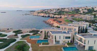 luxo vivendo. aéreo perspectivas do deslumbrante vilas com piscinas em a Mediterrâneo costa do pafos, Chipre. Alto qualidade 4k cenas video