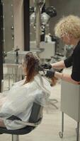 kapper kammen haar- gedurende kleur in een schoonheid salon. mooi vrouw Aan schoonheid behandelingen voor haar- zorg en kleur. hoog kwaliteit 4k beeldmateriaal video