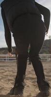rijden opleiding voor kinderen. een meisje in een jockey kostuum gaat naar zitten Aan een paard. hoog kwaliteit 4k beeldmateriaal video
