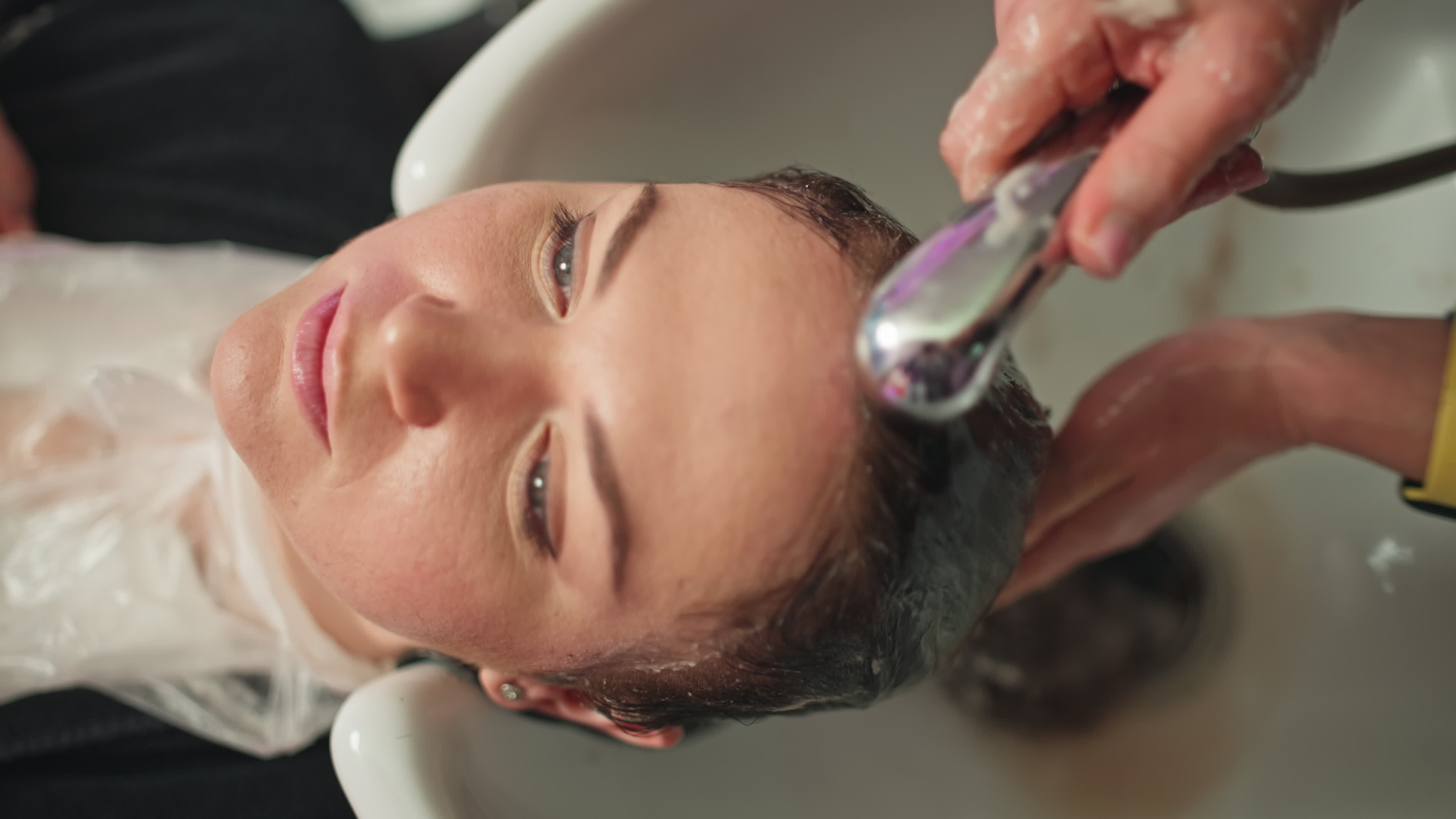 Hair Styling Process. Female Hairdresser Washes Client's Hair for Cut